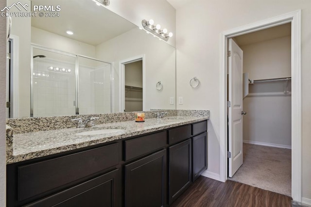 bathroom featuring hardwood / wood-style floors, vanity, and walk in shower