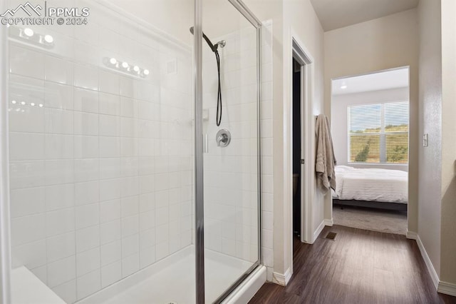 bathroom featuring wood-type flooring and a shower with shower door