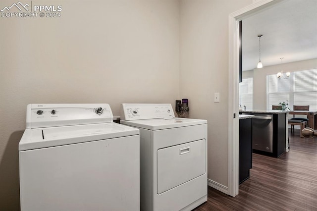 clothes washing area with dark hardwood / wood-style floors, a notable chandelier, and washing machine and clothes dryer