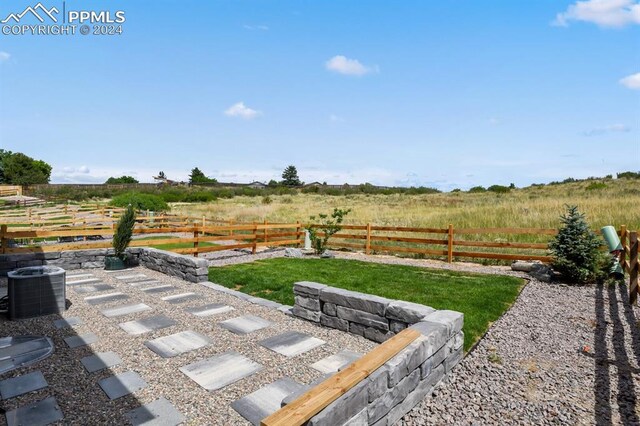 view of yard featuring a rural view and central AC