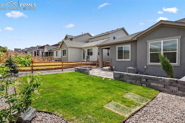 rear view of house with a yard and a patio