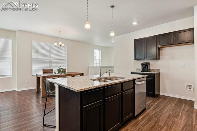 kitchen featuring a kitchen island with sink, sink, pendant lighting, and dark hardwood / wood-style floors