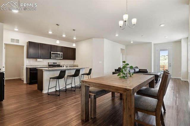 dining space with dark wood-type flooring and a chandelier