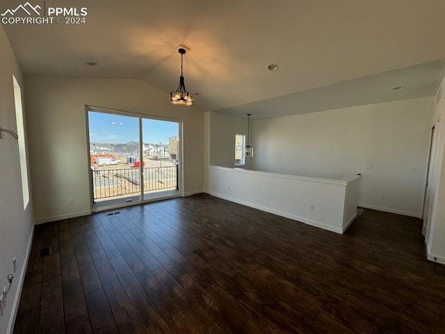 interior space with vaulted ceiling, dark hardwood / wood-style floors, and an inviting chandelier