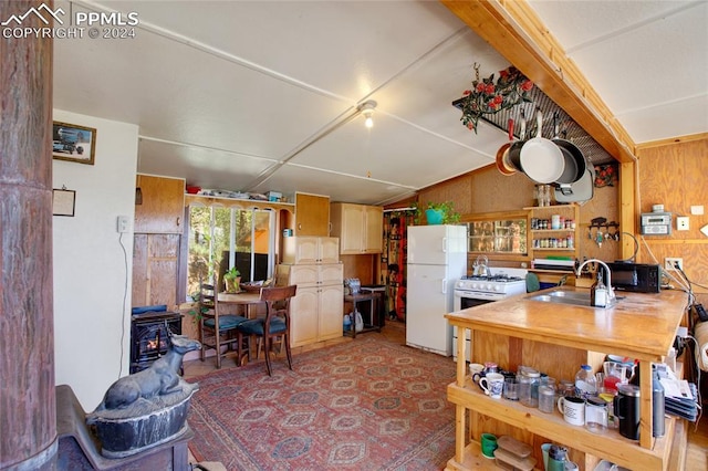 kitchen with sink, a wood stove, and white appliances