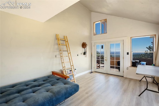 living room featuring high vaulted ceiling, french doors, and hardwood / wood-style flooring