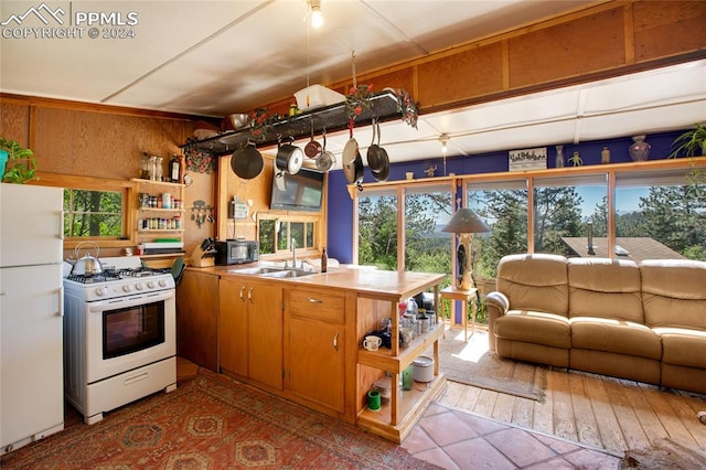 kitchen featuring sink, dark tile patterned floors, and white appliances