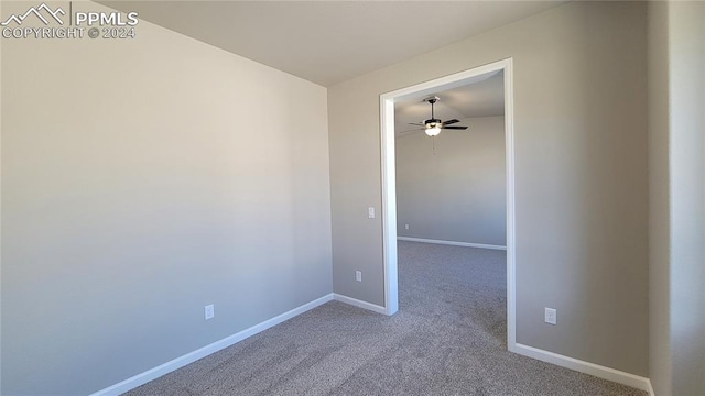 carpeted spare room featuring ceiling fan