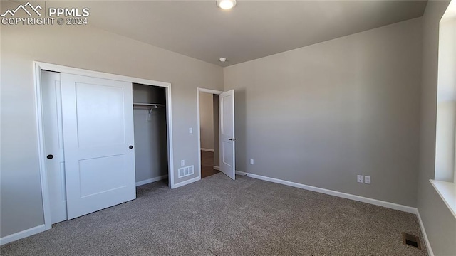 unfurnished bedroom with carpet floors and a closet