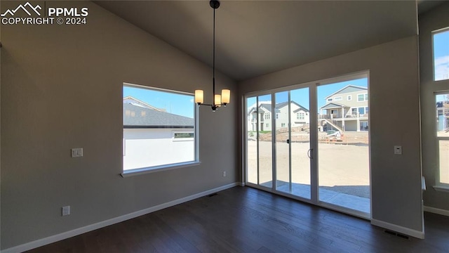 unfurnished dining area featuring a notable chandelier, dark hardwood / wood-style floors, and vaulted ceiling