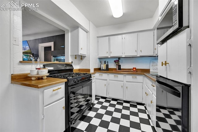 kitchen with butcher block countertops, dishwashing machine, light tile patterned floors, black gas range, and white cabinetry