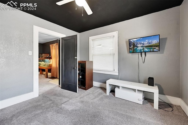 interior space featuring light colored carpet and ceiling fan