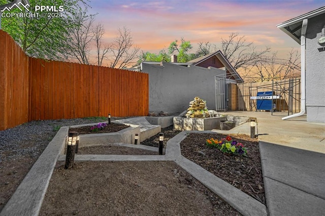 yard at dusk featuring a patio area