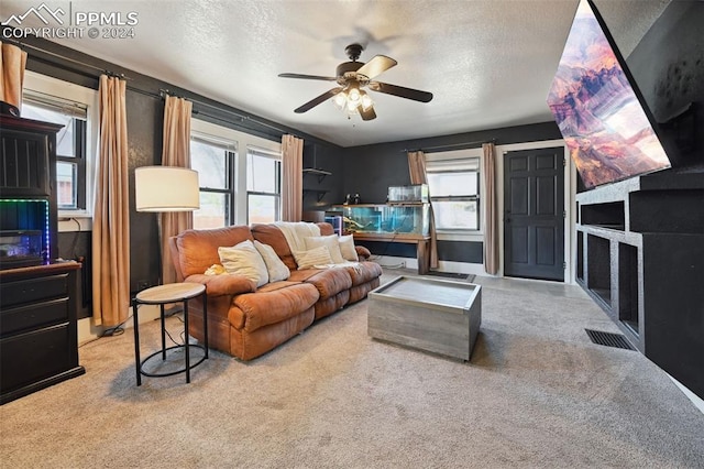 carpeted living room with a textured ceiling and ceiling fan