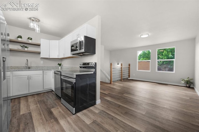 kitchen featuring wood-type flooring, stainless steel appliances, white cabinetry, and sink