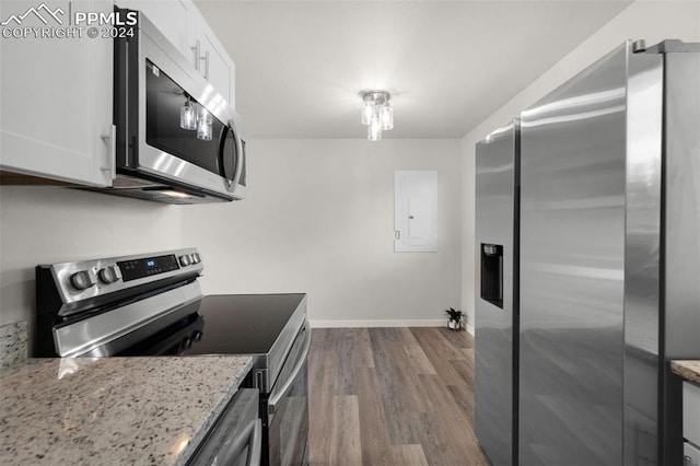 kitchen featuring white cabinets, light stone counters, stainless steel appliances, and light hardwood / wood-style floors