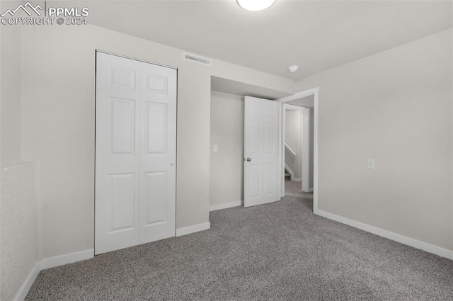 unfurnished bedroom with a closet and carpet flooring