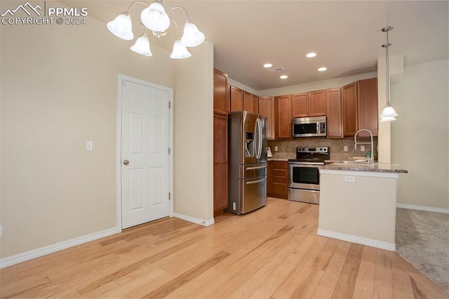 kitchen with pendant lighting, stainless steel appliances, an inviting chandelier, decorative backsplash, and sink