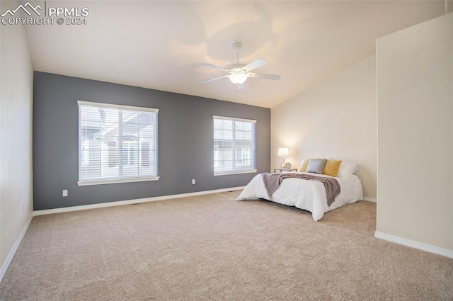 carpeted bedroom with ceiling fan and vaulted ceiling