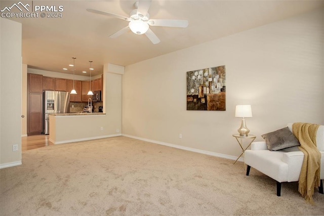 sitting room featuring ceiling fan and light colored carpet