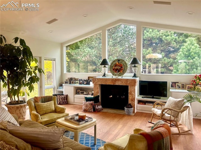 sunroom / solarium with visible vents, a fireplace, and vaulted ceiling