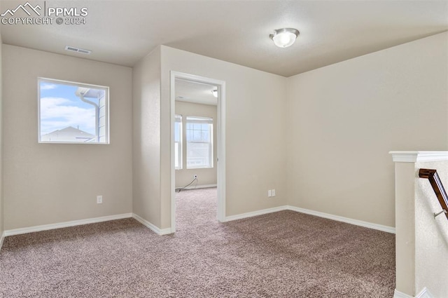 empty room featuring a healthy amount of sunlight and carpet floors