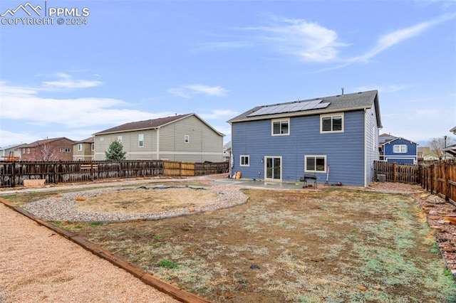 rear view of house featuring a patio and solar panels