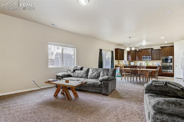 carpeted living room featuring a notable chandelier