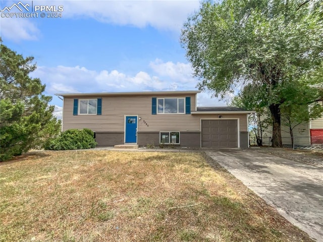 split foyer home with a garage and a front yard