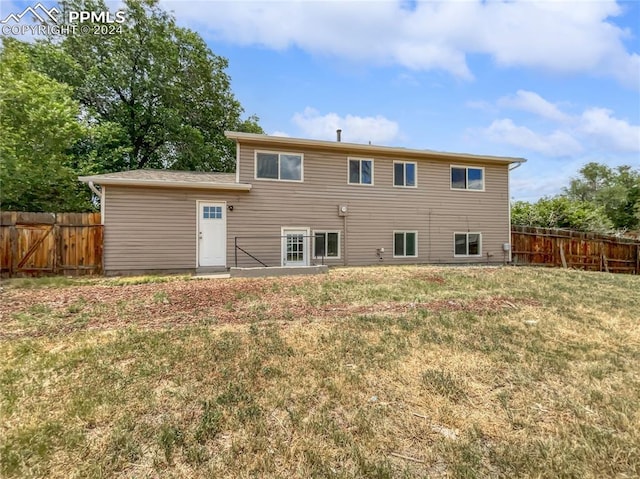 rear view of property with a lawn