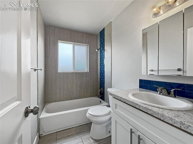 full bathroom with vanity, toilet, decorative backsplash, and tiled shower / bath