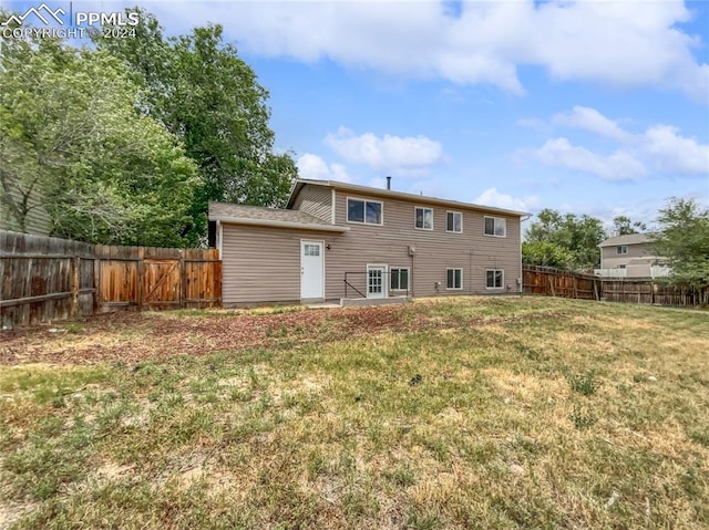 rear view of house with a yard