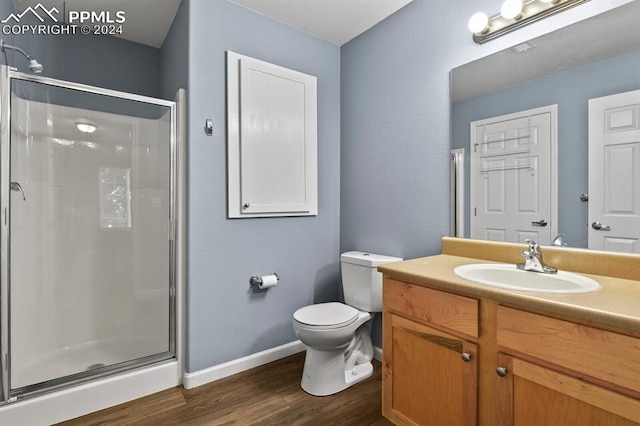 bathroom featuring hardwood / wood-style flooring, toilet, an enclosed shower, and vanity