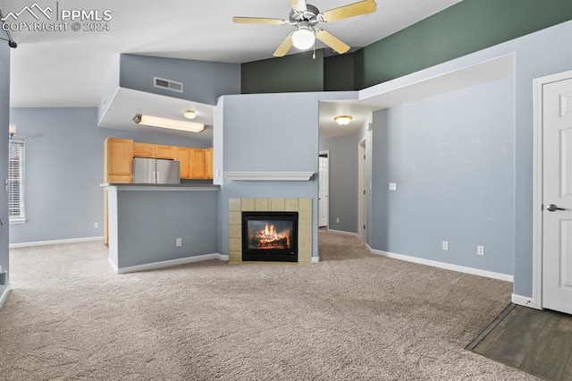 unfurnished living room featuring ceiling fan, light colored carpet, a fireplace, and high vaulted ceiling