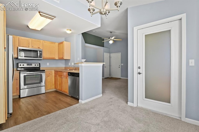 kitchen featuring light brown cabinets, light colored carpet, sink, and appliances with stainless steel finishes