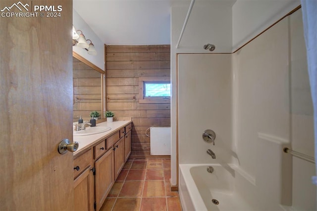 bathroom with tile patterned flooring, vanity, tub / shower combination, and wooden walls