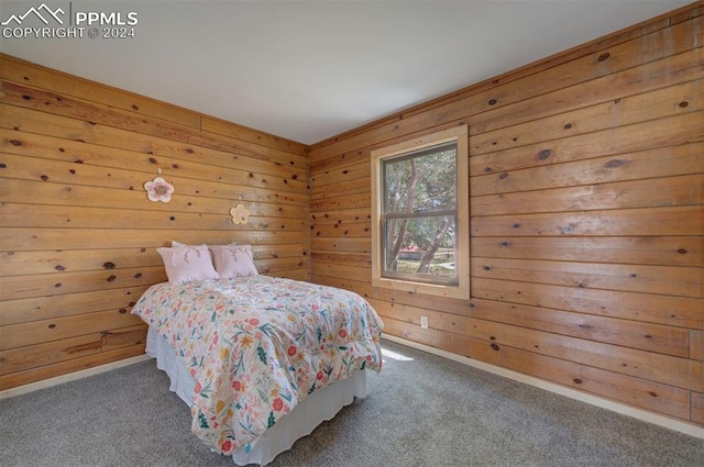 bedroom featuring carpet floors and wood walls