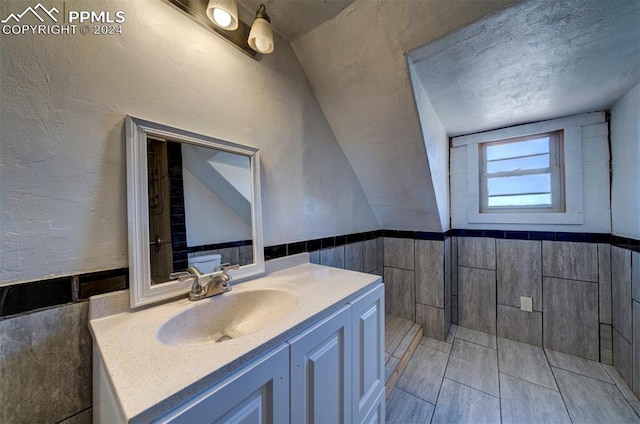 bathroom with vanity and tile walls