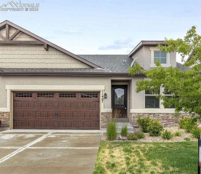 craftsman house with a garage and a front lawn