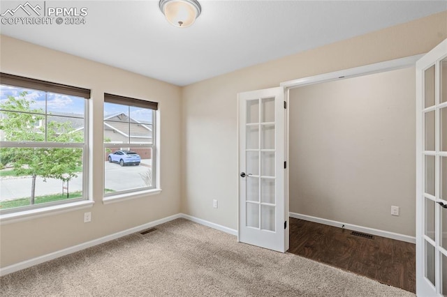 unfurnished room with a wealth of natural light, french doors, and hardwood / wood-style flooring