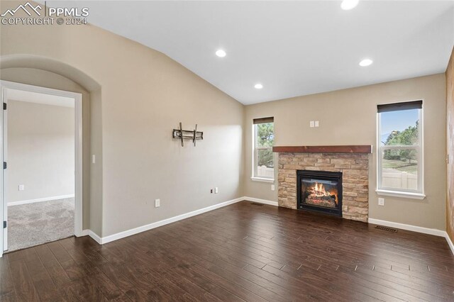 unfurnished living room with dark wood-type flooring, a fireplace, an inviting chandelier, and vaulted ceiling