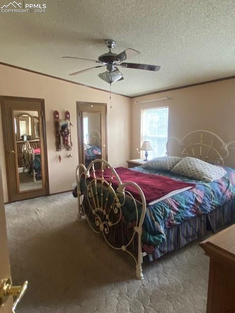 carpeted bedroom featuring a textured ceiling and ceiling fan