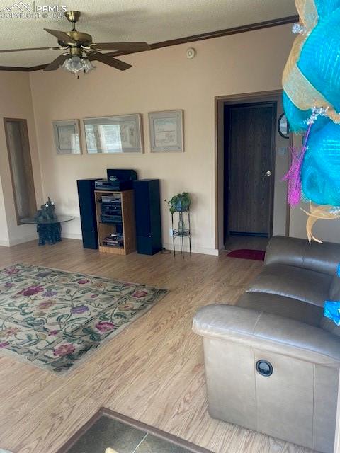 living room with a textured ceiling, hardwood / wood-style flooring, and ceiling fan