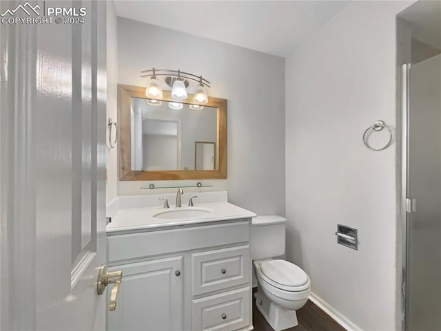 bathroom featuring hardwood / wood-style flooring, vanity, and toilet