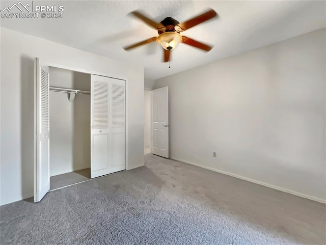 unfurnished bedroom with ceiling fan, a closet, and dark colored carpet