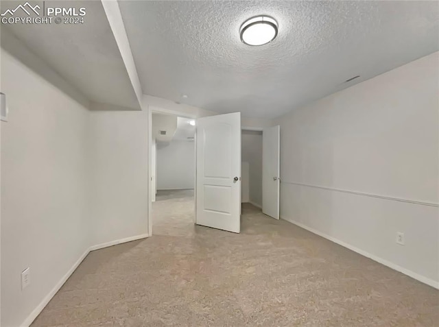 basement with light carpet and a textured ceiling