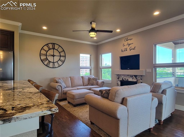 living room with a premium fireplace, ornamental molding, dark hardwood / wood-style floors, and ceiling fan