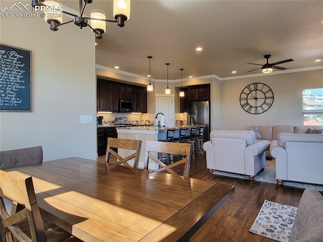 dining room with ornamental molding, dark hardwood / wood-style floors, ceiling fan with notable chandelier, and a textured ceiling