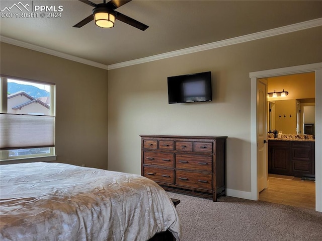 bedroom featuring light carpet, ensuite bath, ornamental molding, and ceiling fan