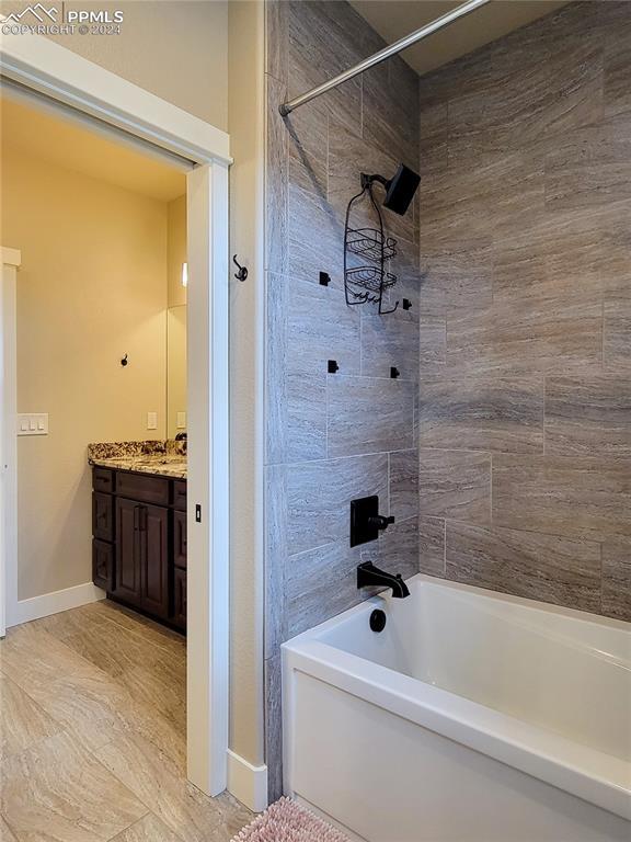 bathroom with vanity and tiled shower / bath